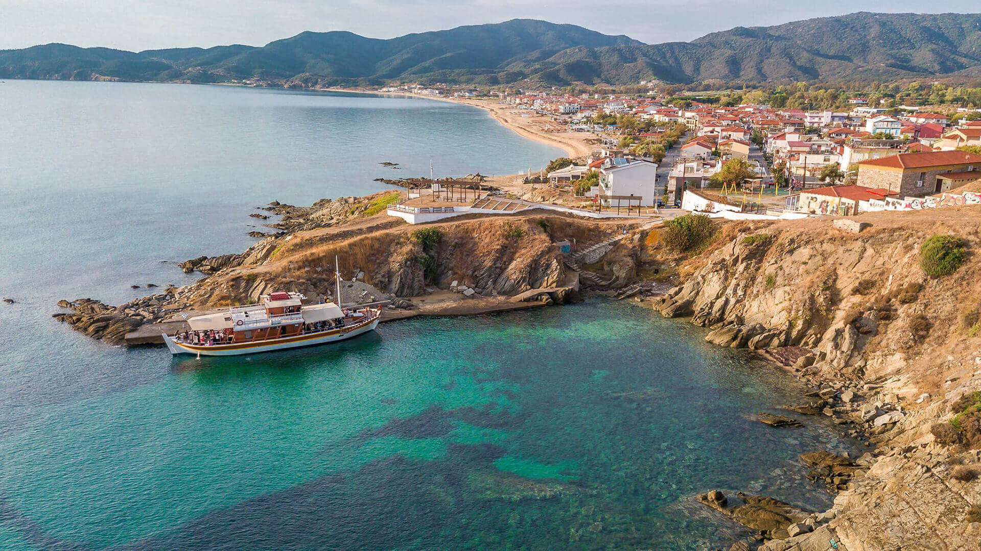 Το μικρό λιμάνι της Σάρτης με φόντο το χωριό